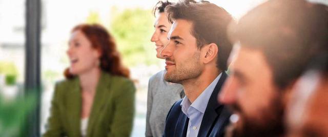 Professionals attentively listening during a business meeting or training session.